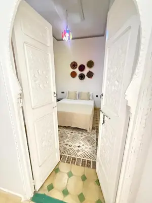 an open door to a bedroom with a bed at Riad Marocain avec jacuzzi sur la terrasse entièrement louer avec 3 chambres pour 6 personnes dans la médina proche de la place Jemma el fna in Marrakech