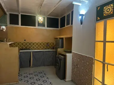 a small kitchen with a stove and a refrigerator at Riad Marocain avec jacuzzi sur la terrasse entièrement louer avec 3 chambres pour 6 personnes dans la médina proche de la place Jemma el fna in Marrakech