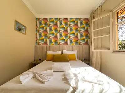 a bedroom with a bed with a painting on the wall at Appartement lumineux avec Jardin à la palmeraie in Marrakech