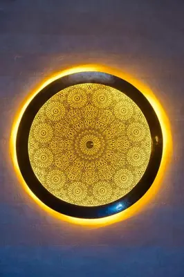 a black plate with a gold design on a table at Riad Marrakech Dar Tivawin 3 rooms With Pool Private Riad in Marrakech