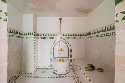a bathroom with a tub in the corner of a room at Riad Marrakech Dar Tivawin 3 rooms With Pool Private Riad in Marrakech