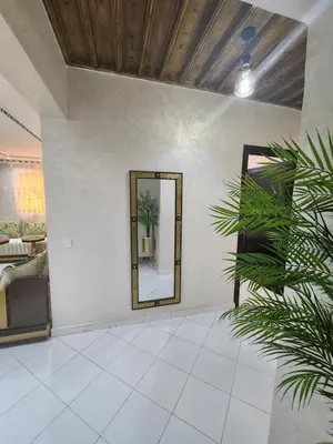 a mirror on a white wall with a plant at 2 bedroom apartment, living room, kitchen in Marrakech in Marrakech