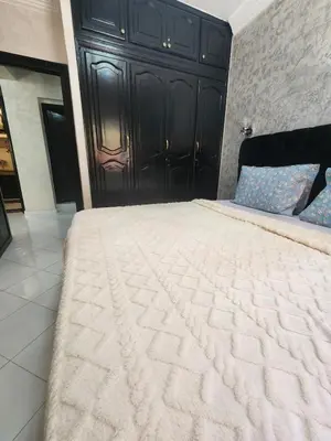 a bedroom with a large bed with a black headboard at 2 bedroom apartment, living room, kitchen in Marrakech in Marrakech