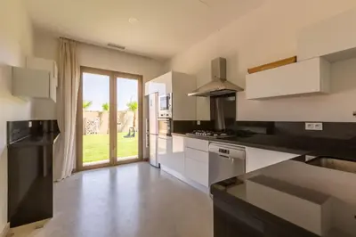 a kitchen with white appliances and a large window at Villa Seyana 1 Zero Vis a Vis et Piscine Chauffee in Marrakech