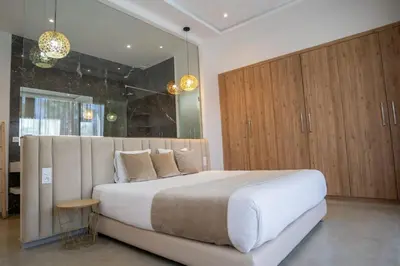a bedroom with a large white bed and wooden cabinets at Villa Seyana 1 Zero Vis a Vis et Piscine Chauffee in Marrakech