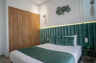 a bedroom with a large bed and a wooden cabinet at Villa Seyana 2 Zero vis a vis, Piscine Chauffee in Marrakech