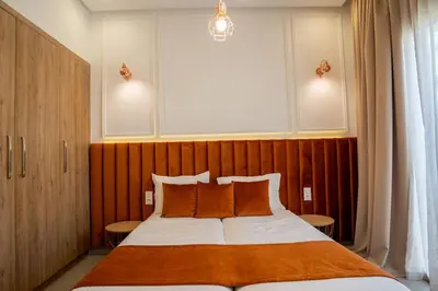 a bedroom with a large bed with orange pillows at Villa Seyana 2 Zero vis a vis, Piscine Chauffee in Marrakech