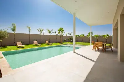 a swimming pool with a table and chairs on a patio at Villa Seyana 2 Zero vis a vis, Piscine Chauffee in Marrakech