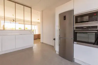 a kitchen with stainless steel appliances and white cabinets at Villa Seyana 5 Zero vis a vis Piscine chauffee in Marrakech