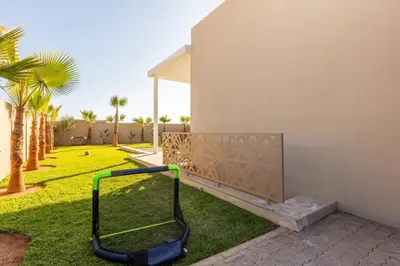 a lawn mower leaned against the side of a house at Villa Seyana 5 Zero vis a vis Piscine chauffee in Marrakech