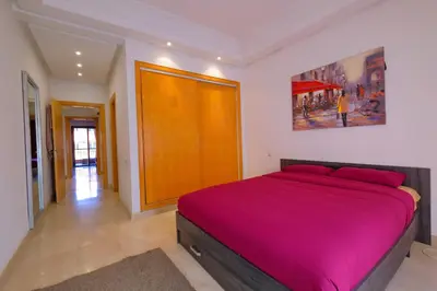 a bedroom with a large bed with a purple blanket at DannaMs Apartment MohamedV Hivernage in Marrakech