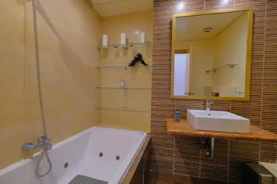 a bathroom with a tub and a sink and a mirror at DannaMs Apartment MohamedV Hivernage in Marrakech