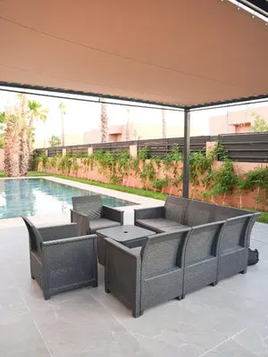 a patio with a table and chairs next to a pool at Villa Crystale - Marrakech in Marrakech