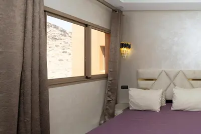 a bedroom with a bed with a window and a purple blanket at Superbe Appart 3 pièces Moderne, Confort avec vue panoramique sur Marrakech plein centre à 7 min a pied de Gueliz in Marrakech
