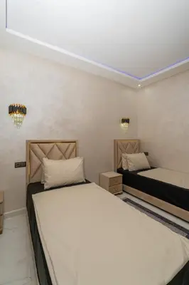a bedroom with two beds and two lights at Superbe Appart 3 pièces Moderne, Confort avec vue panoramique sur Marrakech plein centre à 7 min a pied de Gueliz in Marrakech