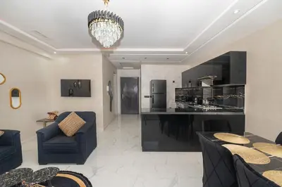 a kitchen and living room with a chandelier at Superbe Appart 3 pièces Moderne, Confort avec vue panoramique sur Marrakech plein centre à 7 min a pied de Gueliz in Marrakech