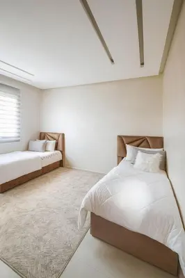 two beds in a bedroom with white walls at cozy villa 3 Rooms pool wifi -Only Family in Marrakech