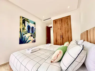 two beds in a room with white walls at Modern and Central Apartment with Terrace and Free Parking in Marrakech