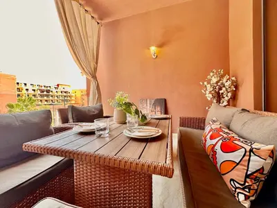 a wooden table sitting on top of a balcony at Modern and Central Apartment with Terrace and Free Parking in Marrakech