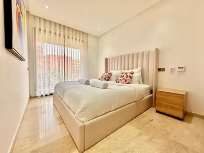 a bedroom with a large bed and a window at Modern and Central Apartment with Terrace and Free Parking in Marrakech