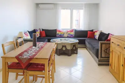 a living room with a couch and a table at Kridarek - Appartement Élégant à Marrakech in Marrakech