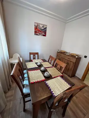 a dining room with a wooden table with chairs at Cozy & Elegant apartment Marrakech in Marrakech