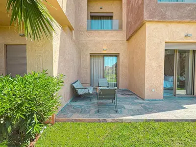 a patio with a table and chairs in front of a building at elegance apartment in Marrakech in Marrakech