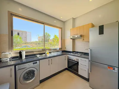 a kitchen with a refrigerator and a sink and a window at elegance apartment in Marrakech in Marrakech