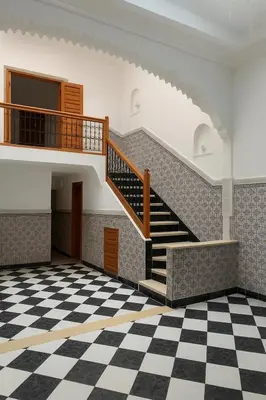 an empty room with a staircase and a checkered floor at Riad Nahara in Marrakech