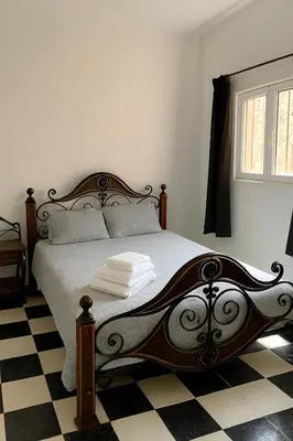 a bedroom with a bed with a black and white checkered floor at Riad Nahara in Marrakech