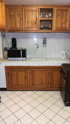 a kitchen with wooden cabinets and a microwave at Riad Nahara in Marrakech