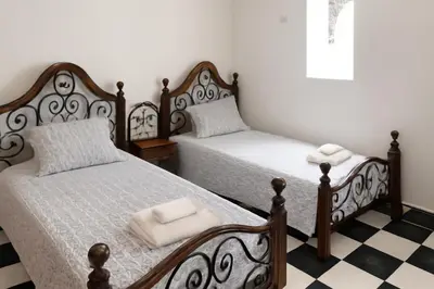 two beds sitting in a room with a checkered floor at Riad Nahara in Marrakech