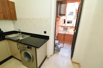 a kitchen with a sink and a washing machine at Superbe T3 neuf - Proche centre - Piscines et Clim - Marrakeck in Marrakech