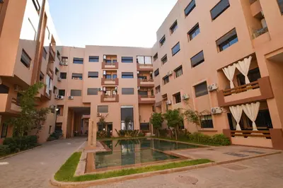 an apartment building with a courtyard with a swimming pool at Superbe T3 neuf - Proche centre - Piscines et Clim - Marrakeck in Marrakech