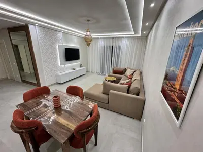 a living room with a table and a couch at Appartement spacieux centre ville quartier dynamique in Marrakech