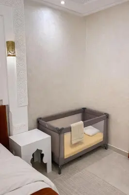 a bedroom with a bed and a bench with a towel at Appartement spacieux centre ville quartier dynamique in Marrakech