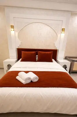 a bedroom with a large bed with two towels on it at Appartement spacieux centre ville quartier dynamique in Marrakech