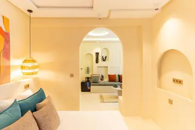 an archway in a living room with a couch at Cosy appartement avec jacuzzi in Marrakech