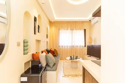 a living room with a couch and a tv at Cosy appartement avec jacuzzi in Marrakech