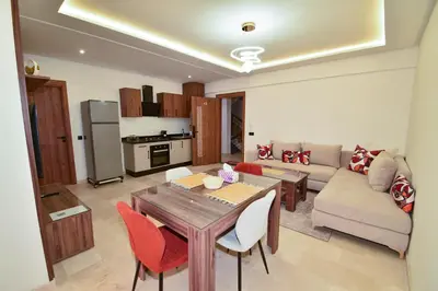 a living room with a table and a couch at Superbe T2 neuf - Proche centre - Piscines et Balcon - Marrakech in Marrakech