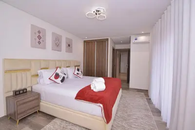 a bedroom with a bed with a red blanket on it at Appart Essalam in Marrakech