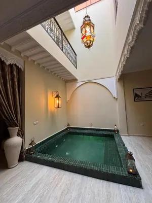 a swimming pool in a room with a chandelier at Riad LALA ASMAA Riad privé in Marrakech
