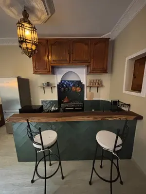 a kitchen with a counter with two stools at it at Riad LALA ASMAA Riad privé in Marrakech
