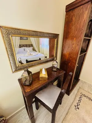 a bedroom with a desk with a mirror and a bed at Riad LALA ASMAA Riad privé in Marrakech