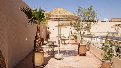 a patio with a table and chairs and an umbrella at Palais Andara Riad And SPA in Marrakech