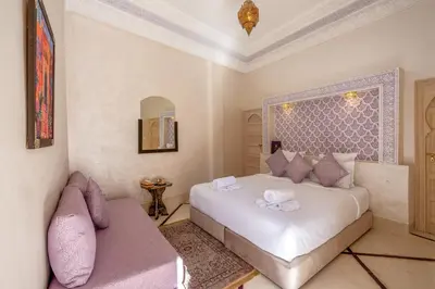 a bedroom with a large white bed and a couch at Palais Andara Riad And SPA in Marrakech