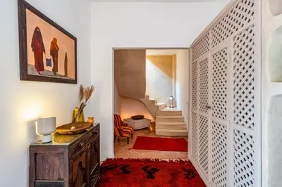 a hallway with a door and a red rug at Riad Litote in the heart of the Kasbah in Marrakech