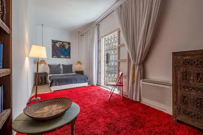 a bedroom with a bed and a red rug at Riad Litote in the heart of the Kasbah in Marrakech