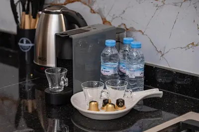 a tray with water bottles and glasses on a counter at Modern Hivernage Studio Retreat Pool & central access in Marrakech