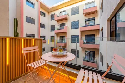 a balcony with a table and chairs and a building at Modern Hivernage Studio Retreat Pool & central access in Marrakech